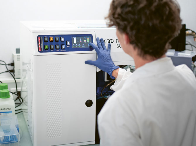 Chercheur de dos devant une machine d'analyse