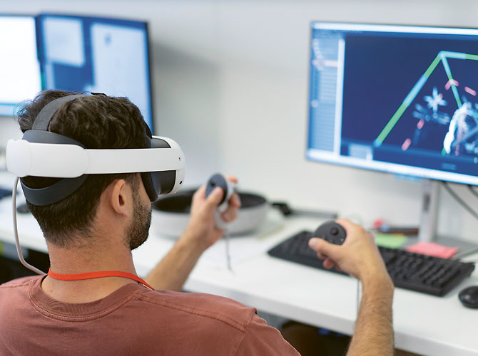 Personne vue de dos avec un masque de VR et devant un écran